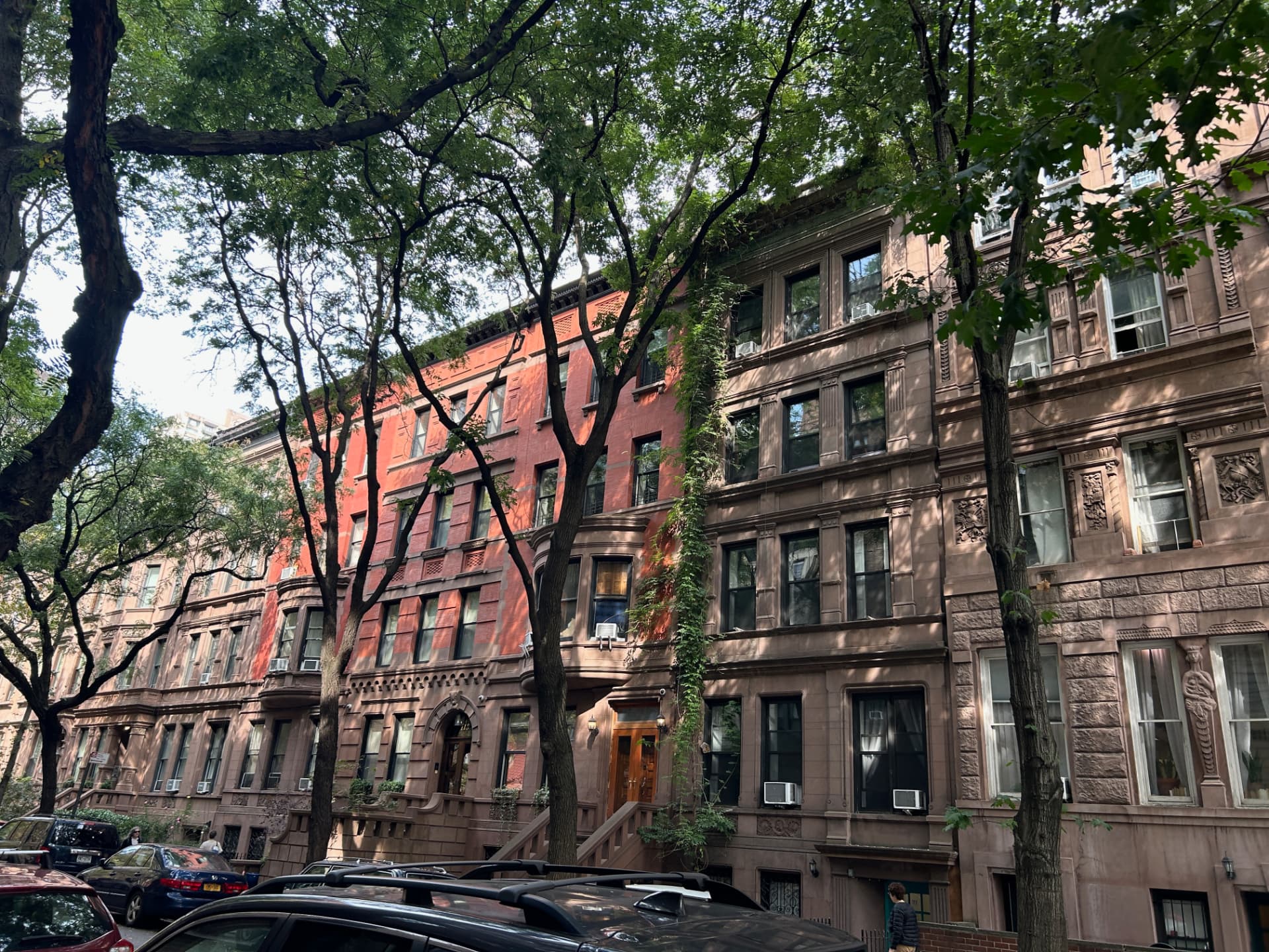 Tree-lined street of New York brownstones with historic facades